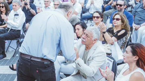 Carlos Caszely y Axel Pickett se estrechan en un saludo afectuoso