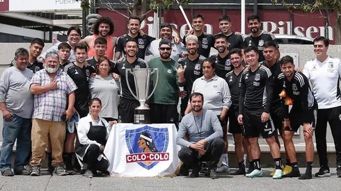 Funcionarios de Colo Colo celebran con el trofeo de campeones.