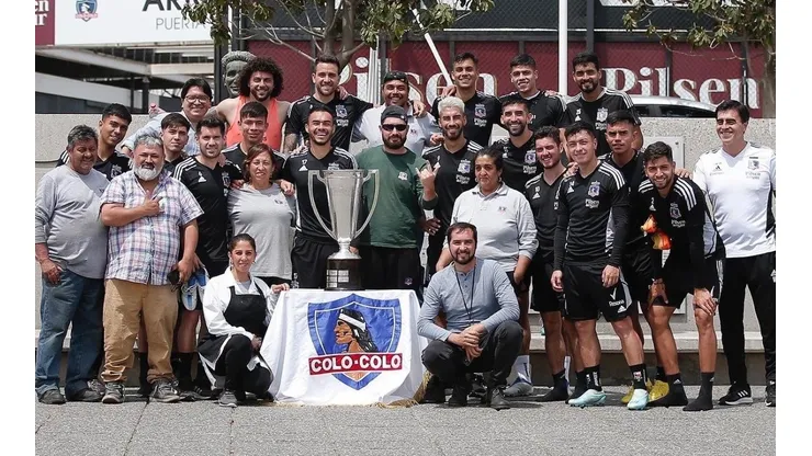 Funcionarios de Colo Colo celebran con el trofeo de campeones.