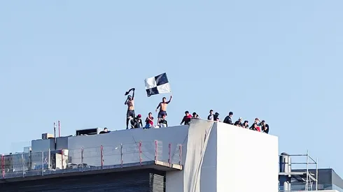 Hinchas de Colo Colo ven el partido en la azotea de un edificio.
