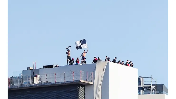 Hinchas de Colo Colo ven el partido en la azotea de un edificio.