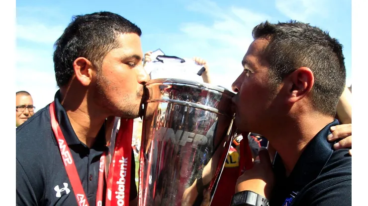 Miguel Riffo besando la copa de campeón del Clausura 2014 junto a Héctor Tapia.
