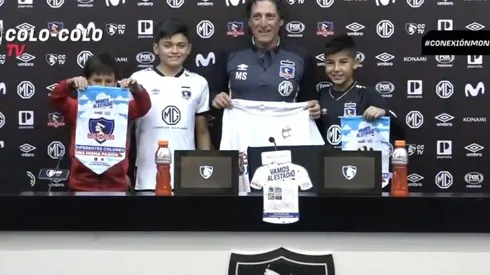 Mario Salas mostrando la camiseta que le dieron los niños